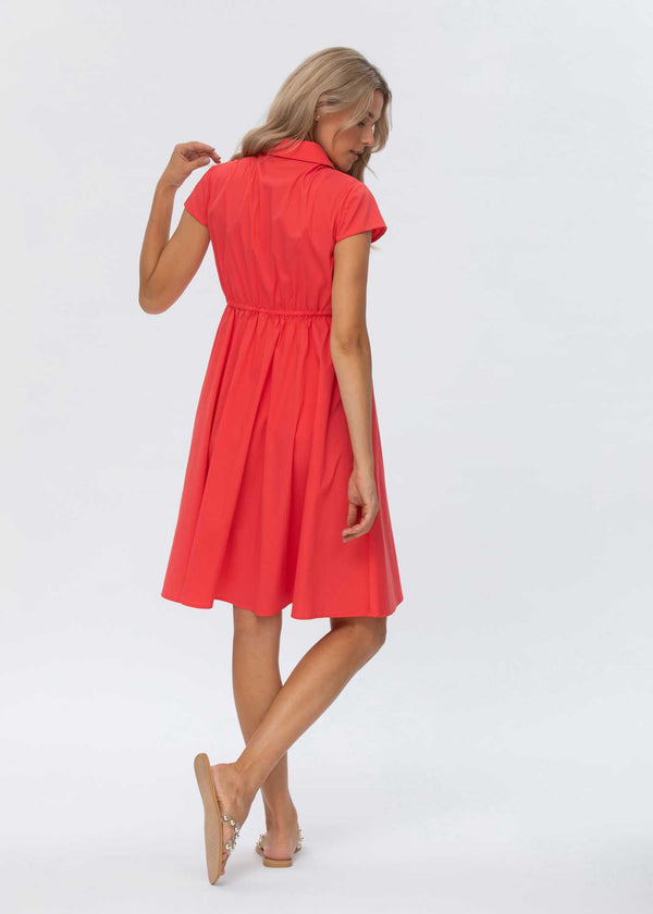 Schwangere Frau trägt rotes, knielanges Blusen-Umstandskleid. Dank der Knöpfe im Brustbereich kann das Kleid auch zum Stillen verwendet werden.