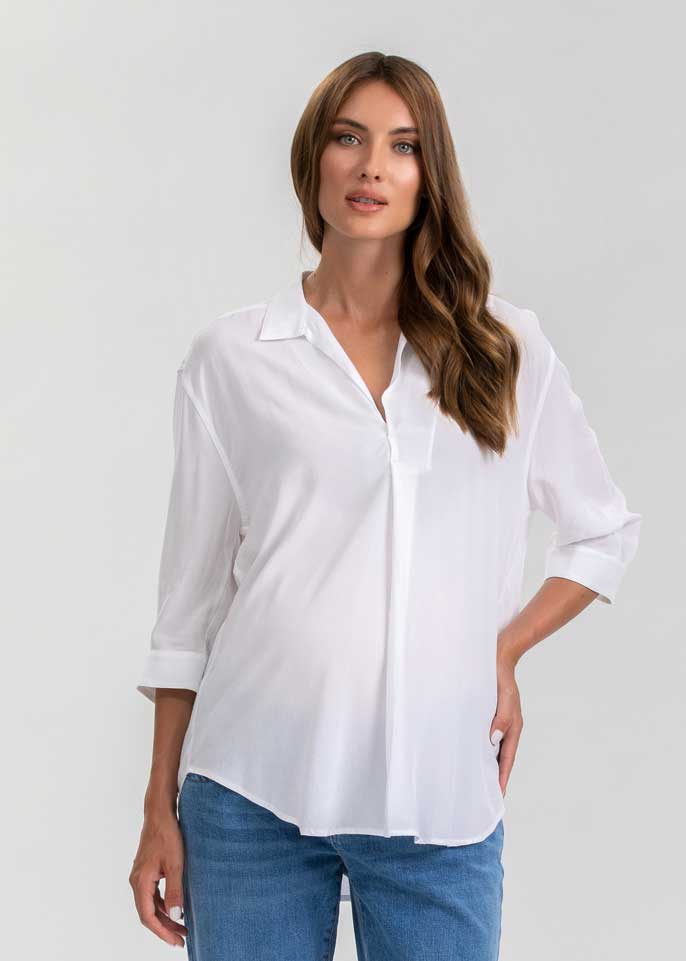 Schwangere Frau trägt weisse Umstandsbluse.  Diese elegante Schwangerschaftsbluse eignet sich für die Arbeit und die Freizeit.