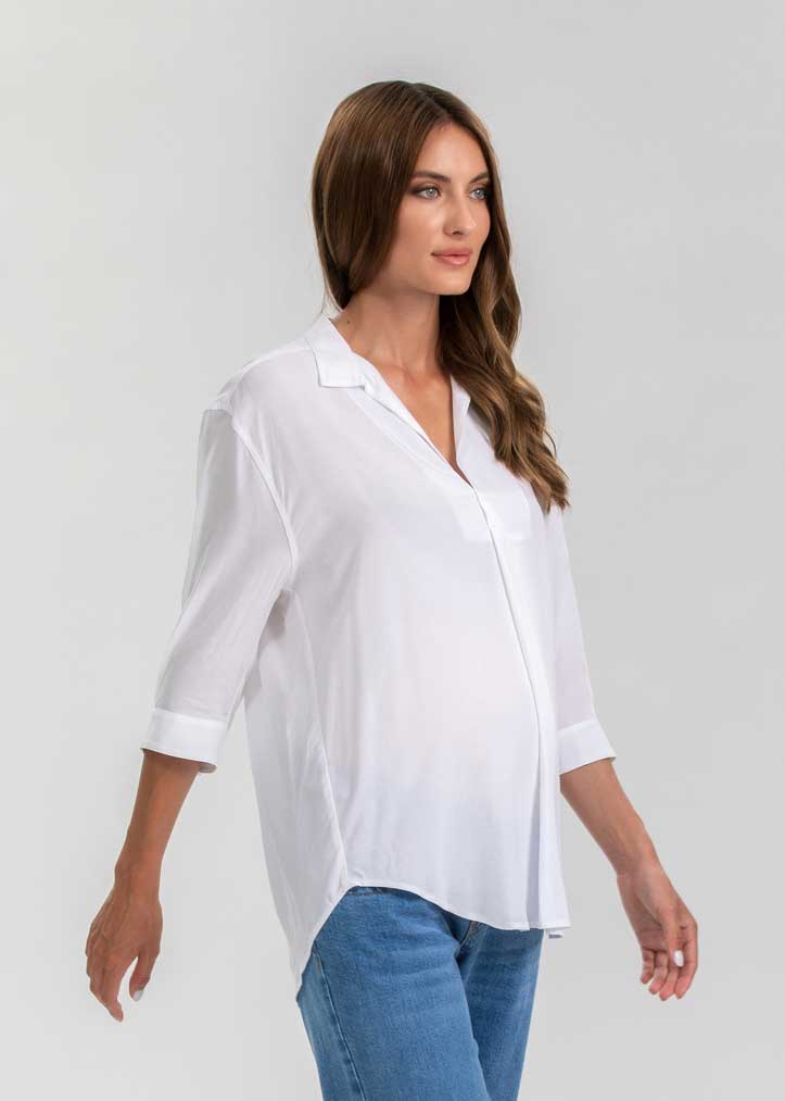 Schwangere Frau trägt weisse Umstandsbluse.  Diese elegante Schwangerschaftsbluse eignet sich für die Arbeit und die Freizeit.
