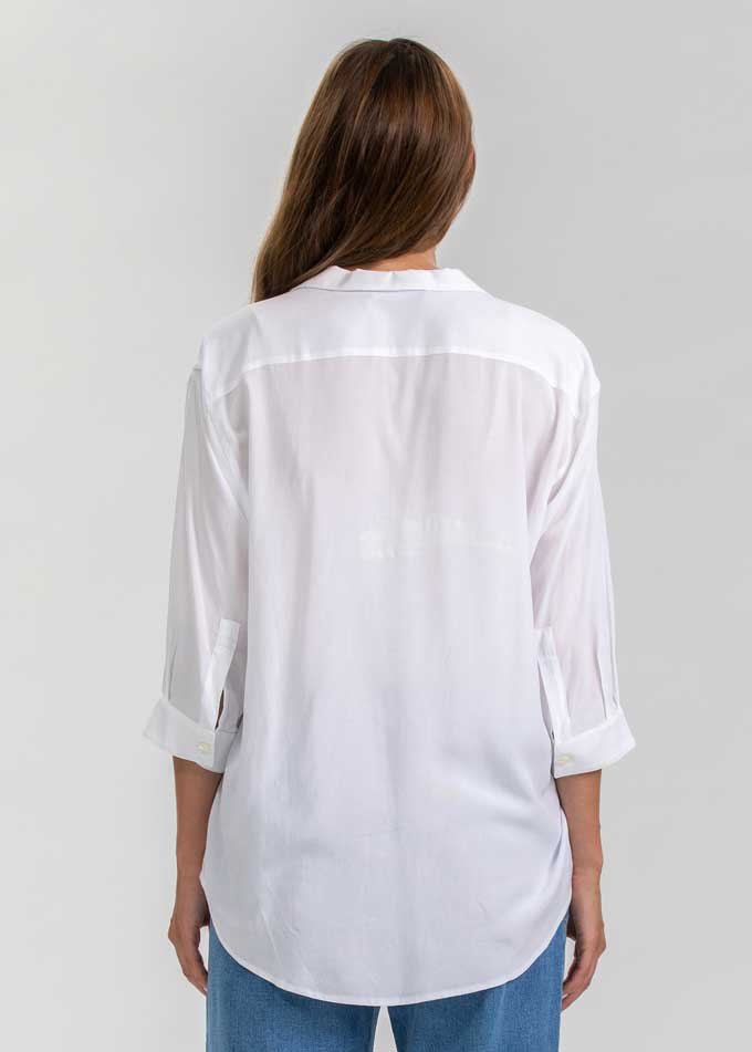 Schwangere Frau trägt weisse Umstandsbluse.  Diese elegante Schwangerschaftsbluse eignet sich für die Arbeit und die Freizeit.