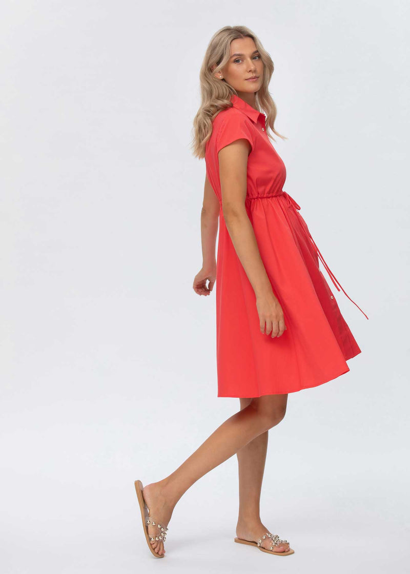 Schwangere Frau trägt rotes, knielanges Blusen-Umstandskleid. Dank der Knöpfe im Brustbereich kann das Kleid auch zum Stillen verwendet werden.
