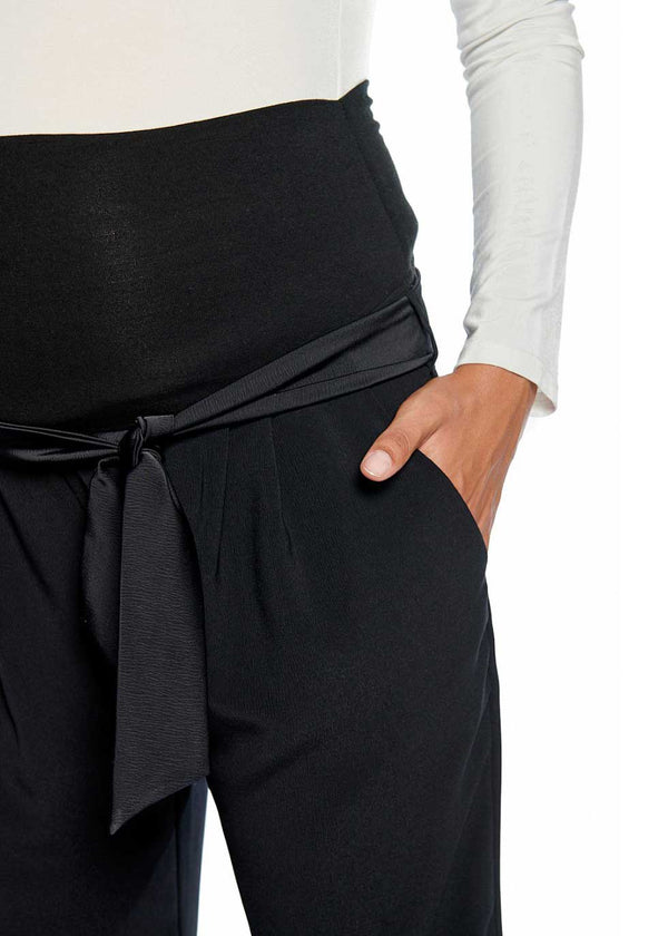 Schwangere Frau trägt eine elegante, schwarze Schwangerschaftshose aus Crêpe mit Jerseybund, Detailansicht