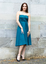 Frau trägt elegantes Seidenkleid in Blau mit Flügel-Ärmeln.