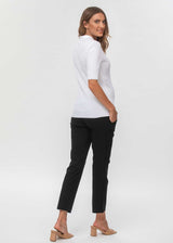 Schwangere Frau trägt schwarze, eng geschnittene Umstands-Business-Hosen in 7/8-Länge.