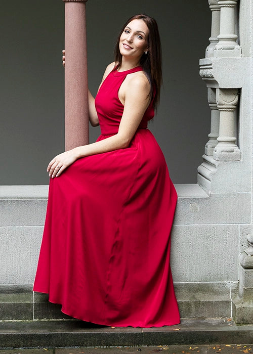 Frau trägt modernes Seiden-Abendkleid in Rot.